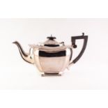 CIRCA 1920,s GEORGIAN STYLE SILVER TEA POT of oval form with blackwood finish and angular handle and