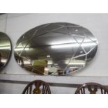 A LARGE MODERN OVAL FRAMELESS WALL MIRROR