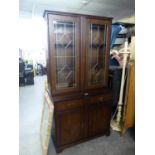 A REPRODUCTION DISPLAY CABINATE WITH GLAZED DOORS TO UPPER SECTION, CUPBOARDS AND DRAWERS BELOW