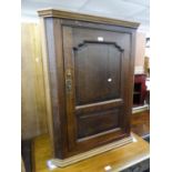 ANTIQUE OAK MURAL CORNER CUPBOARD WITH A FRAMED PANEL DOOR, CANTED SIDES