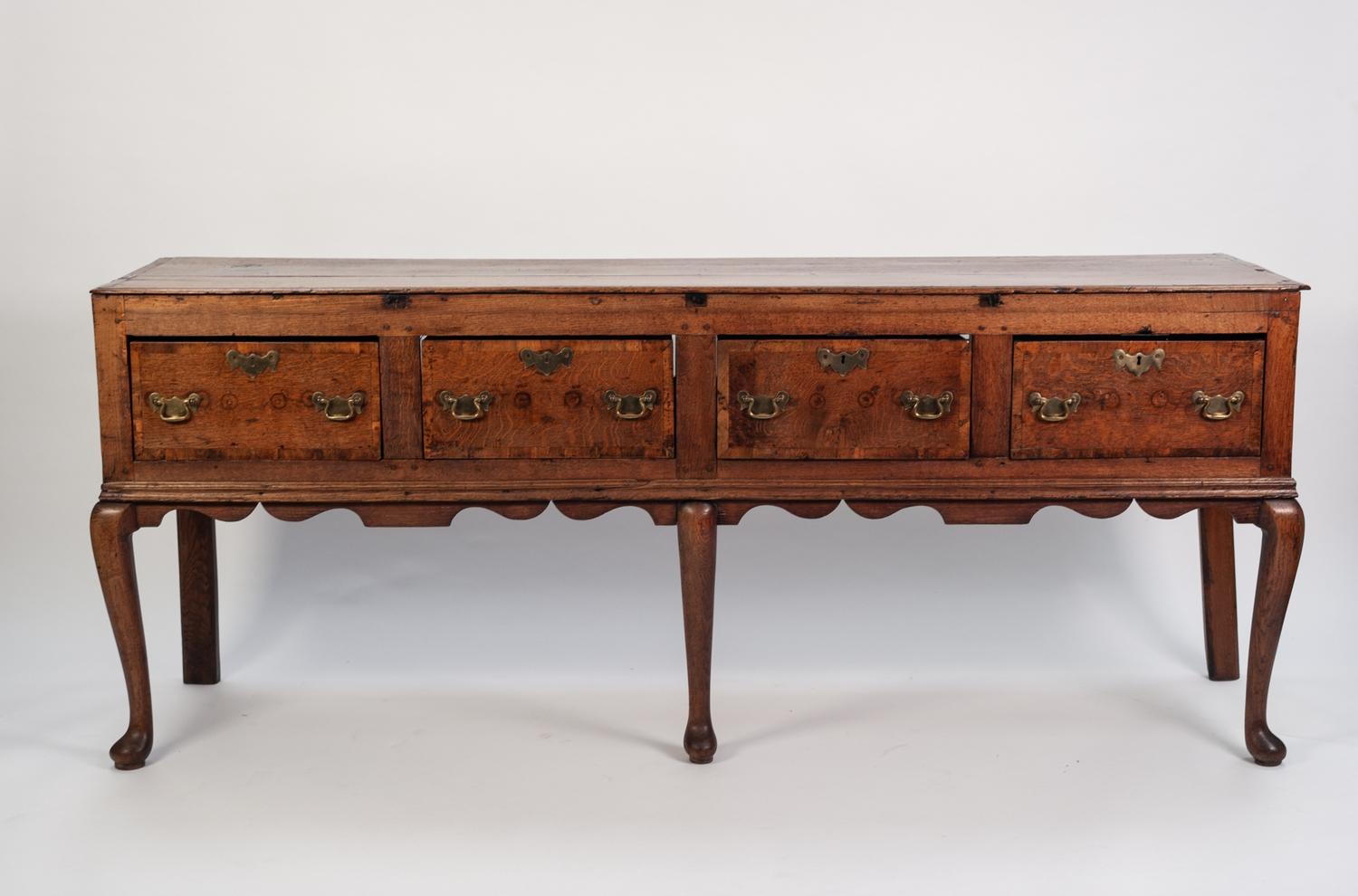 LATE EIGHTEENTH CENTURY CROSSBANDED OAK DRESSER BASE, the moulded oblong top above four deep