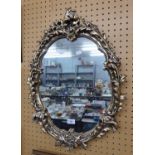 AN OVAL WALL MIRROR, IN GILT FRAME