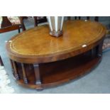 A REPRODUCTION OVAL LEATHER INSET TOP TWO TIER COFFEE TABLE