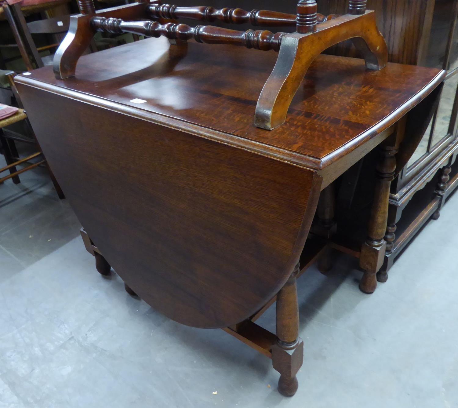 A LARGE OAK OVAL GATELEG DINING TABLE, ON BALUSTER SUPPORTS, APPROX 6' X 3'6"