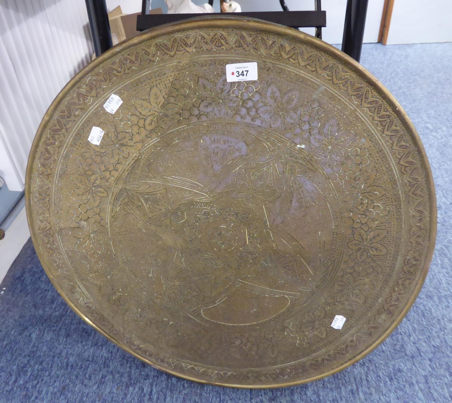 A CIRCULAR BRASS WALL PLAQUE WITH DECORATION