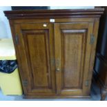AN ANTIQUE OAK TWO DOOR DWARF CUPBOARD WITH 'H' HINGES, QUADRANT PILATER FORECORNERS ON LATER STAND,