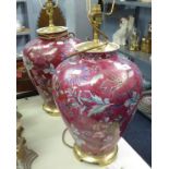 A PAIR OF MODERN PORCELAIN BLAUSTER TABLE LAMPS, HAVING A RED GROUND WITH DECORATIVE FLORAL