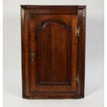 LATE EIGHTEENTH CENTURY OAK CORNER CUPBOARD, the moulded cornice above a cupboard with fielded,