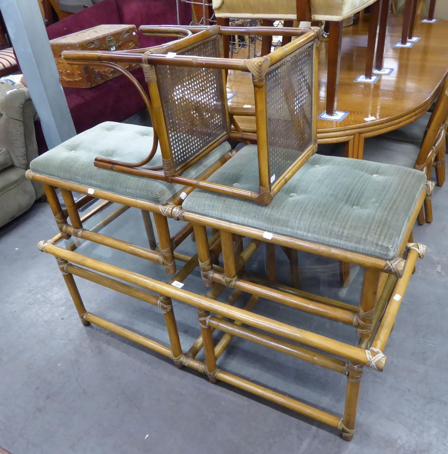 A LARGE BAMBOO COFFEE TABLE WITH GLASS TOP, A PAIR OF SIMILAR BAMBOO FOOTSTOOLS WITH UPHOLSTERED