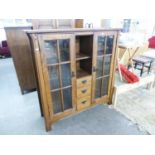 ARTS & CRAFTS STYLE OAK DISPLAY CABINET WITH CENTRE OPEN COMPARTMENT OVER A NEST OF THREE SHORT