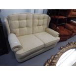 A TWO SEATER MODERN SOFA, PADDED THROUGHOUT WITH BUTTON BACKS IN CREAM CHENILLE FABRIC