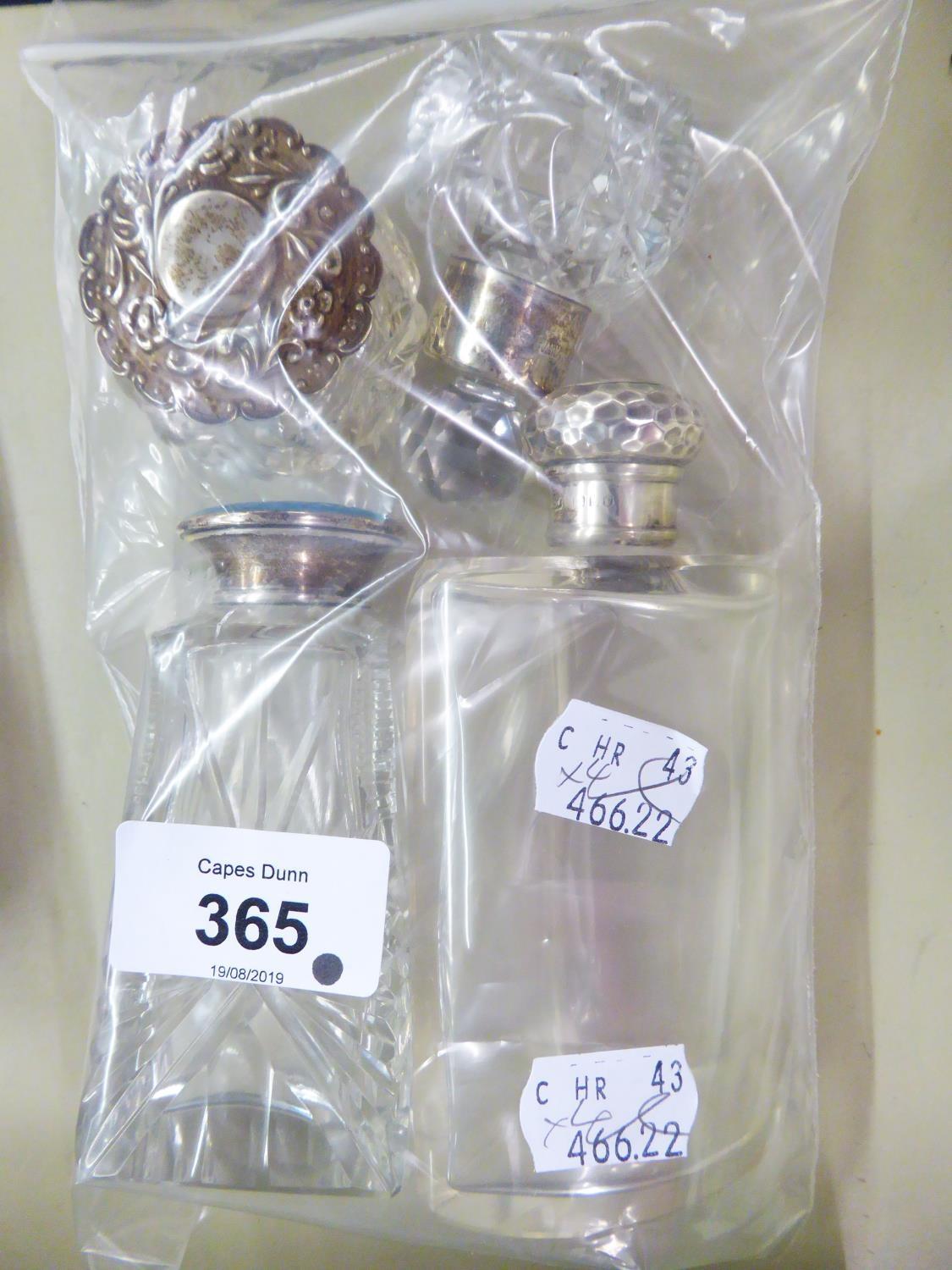 FOUR GLASS BOTTLES OR JARS WITH SILVER COLLARS OR LIDS, (4)
