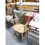 A LIGHT OAK ROCKING CHAIR WITH SPINDLE BACK AND ARMS