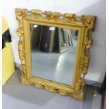 A HEAVY ORNATE GILT FRAMED WALL MIRROR