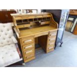EDWARDIAN OAK ROLL TOP KNEEHOLE DESK, THE ENCLOSED TOP REVEALING FITTED COMPARTMENTS OVER A BASE