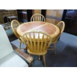 A BEECHWOOD CIRCULAR EXTENDING DINING TABLE, WITH HEATPROOF TOP, WITH FOLDING LEAF BELOW, ON