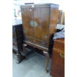 A MAHOGANY COCKTAIL CABINET, HAVING TWO DOORS OVER ONE LONG DRAWER, THE MIRRORED INTERIOR HAVING