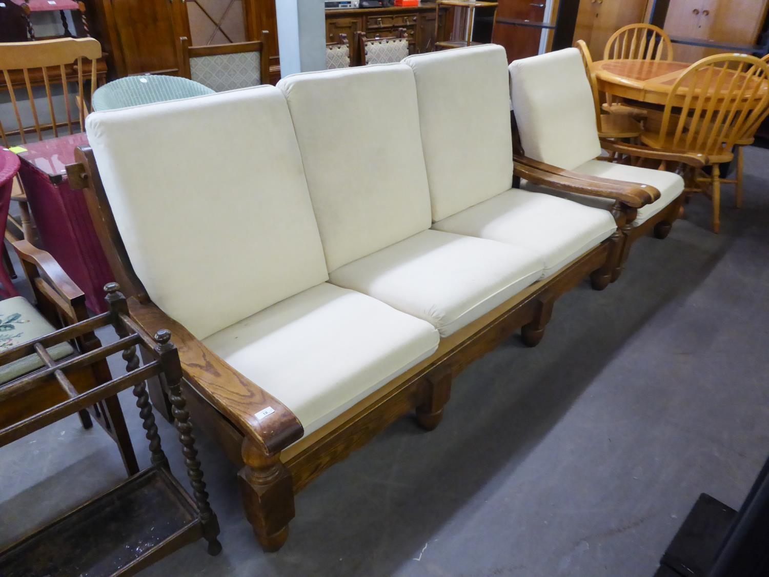 AN OAK FRAMED THREE SEATER SETTEE AND MATCHING LOUNGE ARMCHAIR, WITH LOOSE BACK AND SEAT CUSHIONS