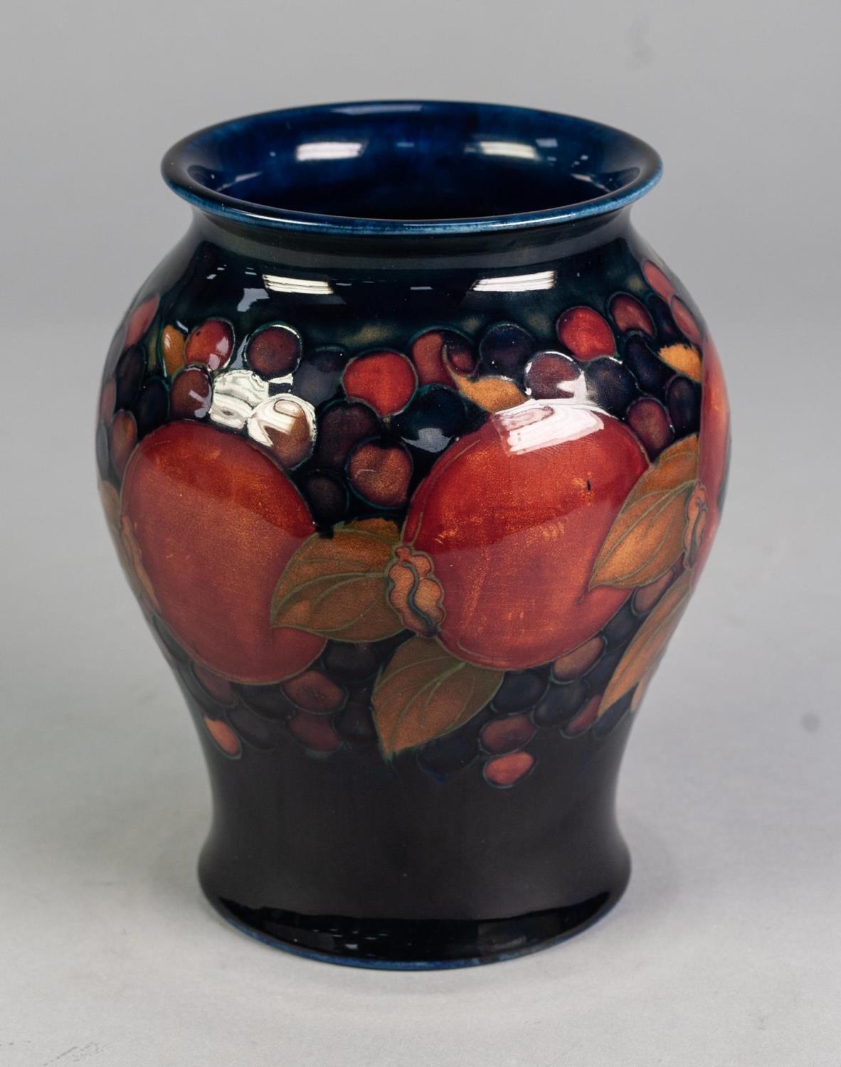 WILLIAM MOORCROFT POTTERY INVERTED BALUSTER SHAPE VASE, pomegranate and berry decorated, on a dark