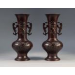 A PAIR OF JAPANESE LATE MEIJI PERIOD PATINATED COPPER ALLOY HANDLED VASES, each cast in low relief