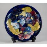 WALTER MOORCROFT CLEMATIS PATTERN TUBE LINED POTTERY PLAQUE, of circular, slightly dished form,