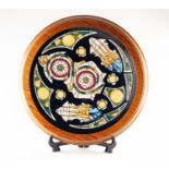 MODERN MOORCROFT ARTIST SIGNED LIMITED EDITION TUBE LINED POTTERY CIRCULAR PLAQUE, of slightly