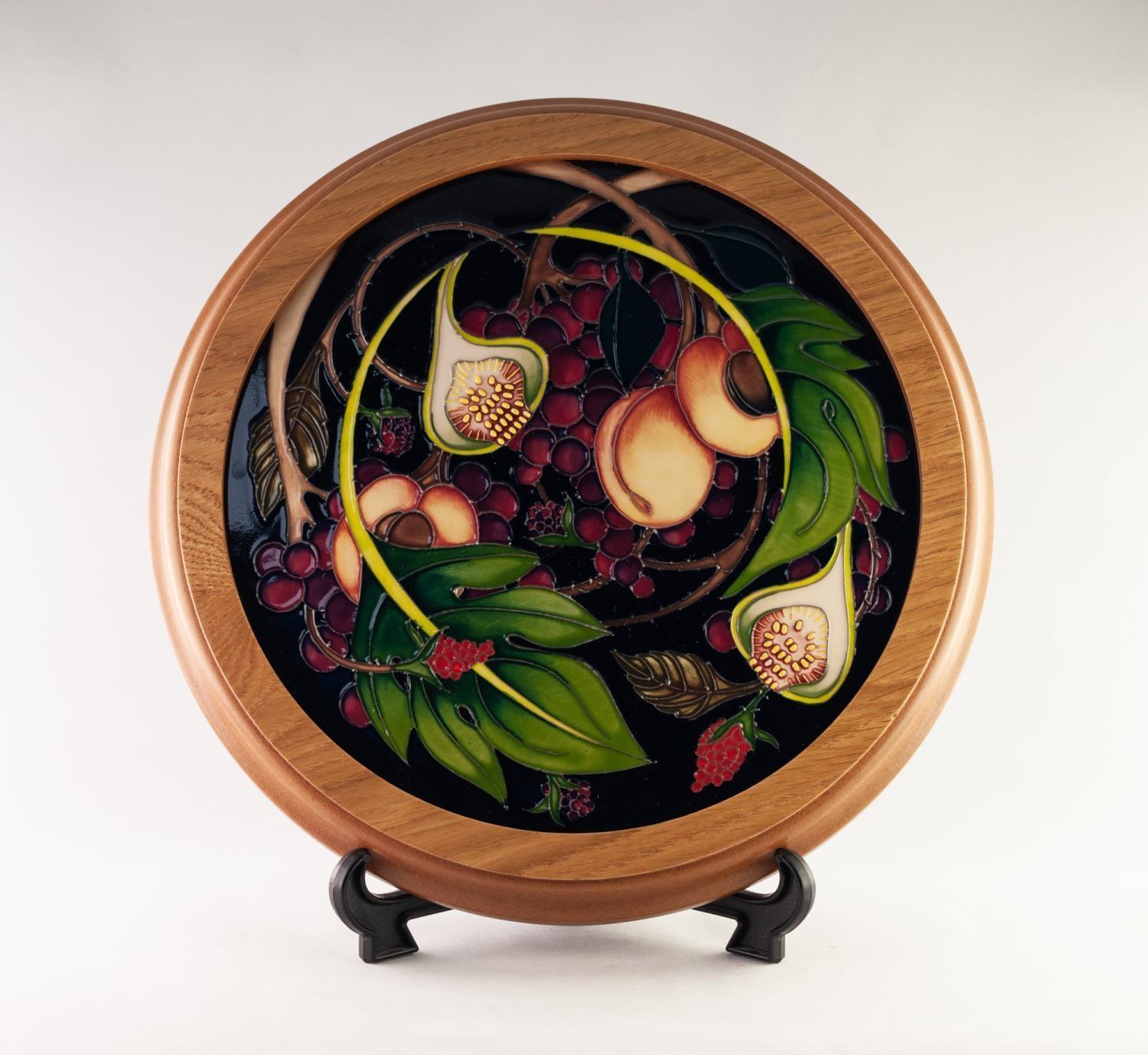 MODERN MOORCROFT ?QUEEN?S CHOICE? TUBE LINED POTTERY CIRCULAR PLAQUE, in oak frame, decorated in