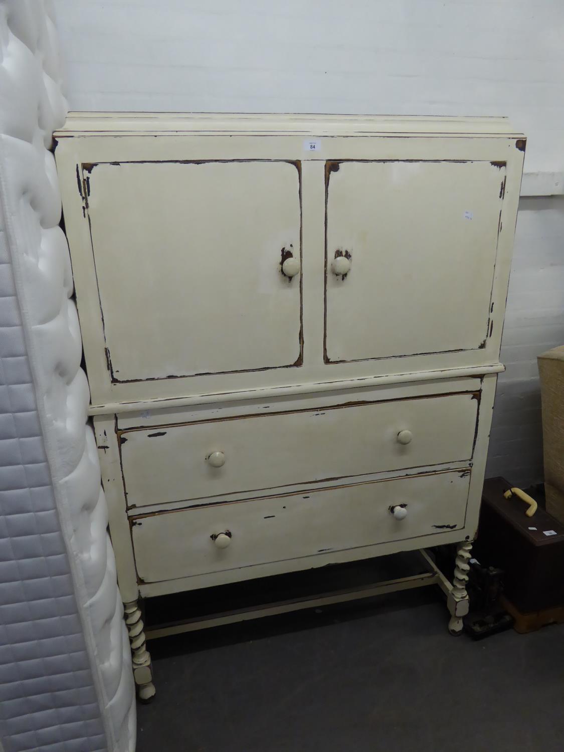 AN OAK CUPBOARD ON CHEST HAVING SPIRAL LEGS, PAINTED AND DISTRESSED