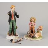 TWO CAPO DI MONTE TINTED BISQUE FIGURES, one modelled as two children with a puppy and basket,