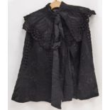 VICTORIAN BLACK CAPE, having broderie anglaise style outer layer with floral and shaped eyelets,
