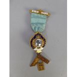 9ct GOLD AND ENAMELLED MASONIC BADGE WITH RIBBON AND GOLD PIN BAR AND PENDANT SET SQUARE, the centre