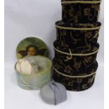 SET OF FOUR GRADUATED CIRCULAR HAT BOXES covered in black plush fabric with gold foliate
