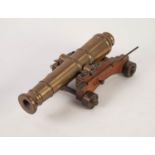 A 20th CENTURY HEAVY BRASS MAN O' WAR MINIATURE CANNON ON AN OAK CARRIAGE WITH BRASS WHEELS,