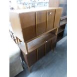 A PAIR OF TEAK LOW RECORD CABINETS, EACH WITH TWO BI-FOLD DOORS, ON SQUARE TAPERING LEGS, 3' WIDE