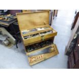 A LARGE POLISHED WOOD TOOL BOX, WITH METAL END CARRYING HANDLES AND A QUANTITY OF HAND TOOLS FOR