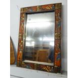 A RECTANGULAR UPRIGHT WALL MIRROR IN UNUSUAL CHANNELLED METAL FRAME AND COLD PAINTED STYLISED