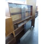A PAIR OF TEAK LOW AND LONG BOOKCASES, EACH WITH TWO GLASS SLIDING DOORS, ON SQUARE TAPERING LEGS,