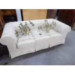 A MODERN ROUND BACKED CHESTERFIELD THREE SEATER SETTEE, COVERED IN CREAM AND FOLIATE FABRIC