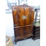 REPRODUCTION FLAME MAHOGANY COCKTAIL CABINET, THE UPPER CUPBOARD HAVING MIRRORED INTERIOR, TWO GLASS