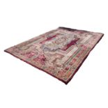 WASHED INDIAN CARPET WITH WINE RED FIELD with large off-white floral centre oval medallion and