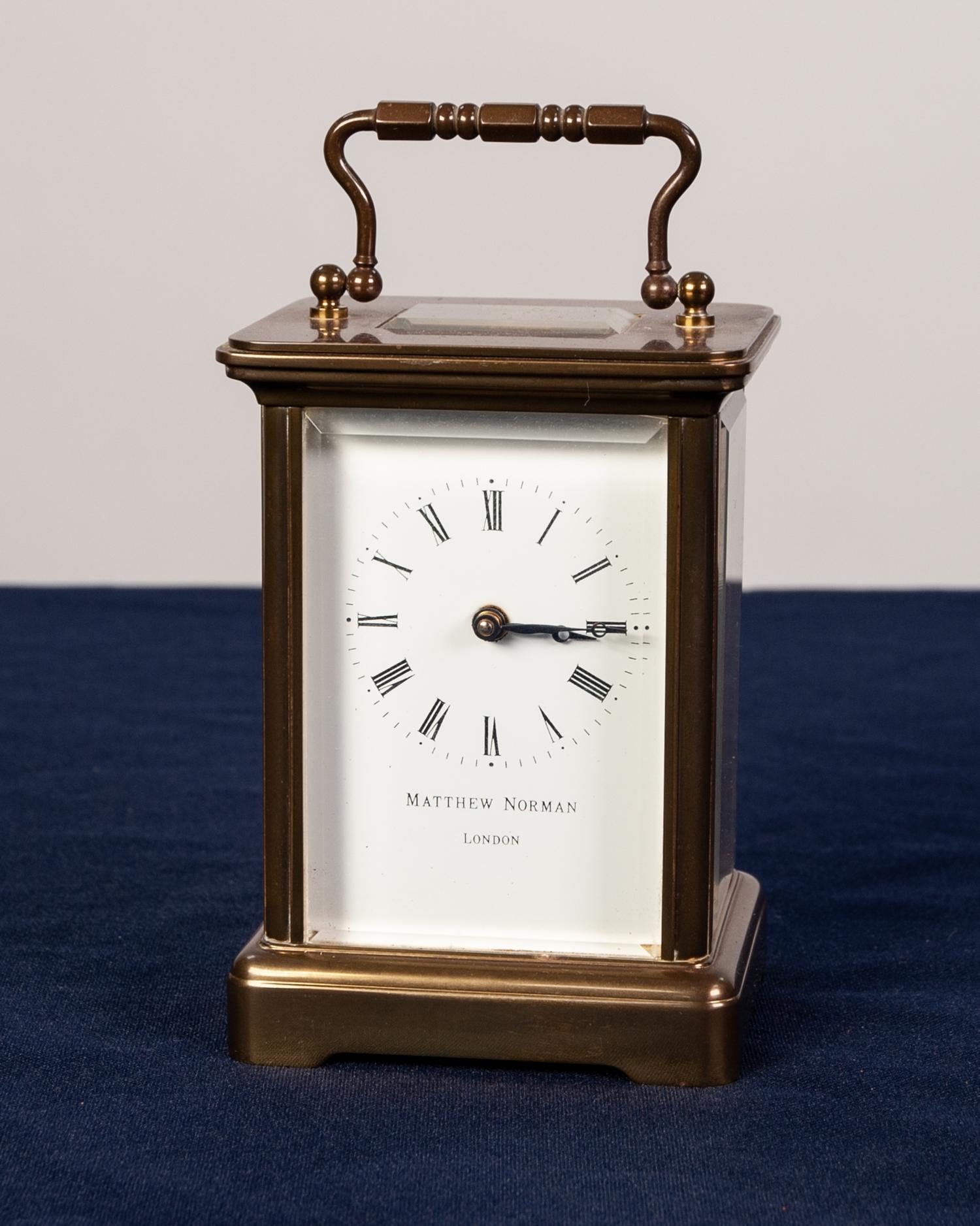 A POST WAR ENGLISH BRASS CASED CARRIAGE CLOCK the white enamel dial inscribed "Mathew Norman,