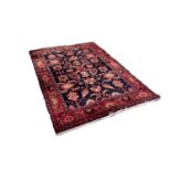 HAMADAN PERSIAN RUG with all-over Heratic design on a black background, the principal border crimson