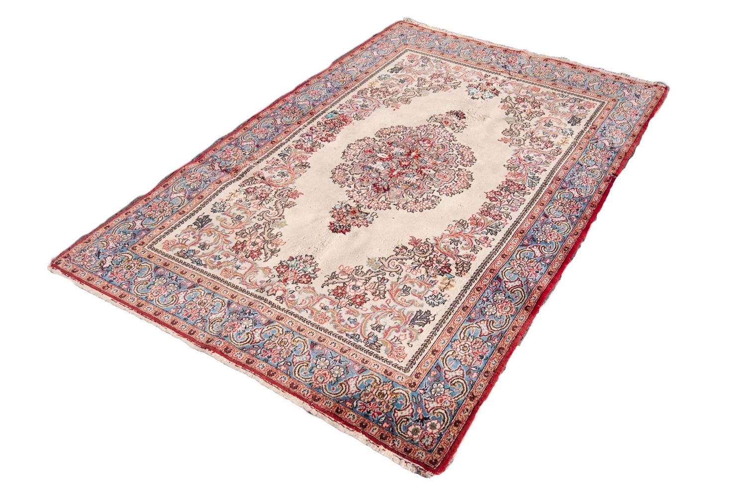 QUM PERSIAN WOOL RUG with floral centre medallion with pendant and surround, on plain white field,