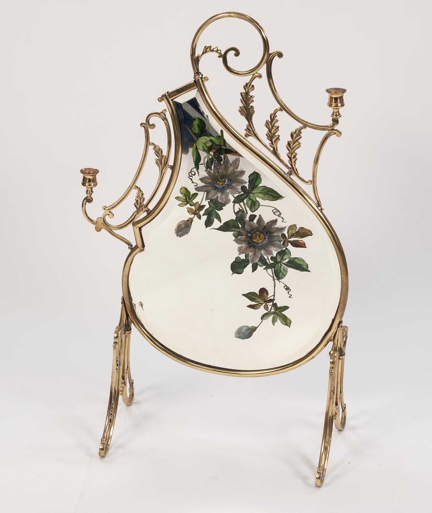 TWENTIETH CENTURY BRASS FRAMED AND MIRROR PAINTED FIRE SCREEN, the shaped, bevel edged plate painted