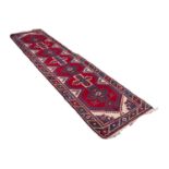 TURKISH RUNNER with row of seven four point star pattern pole medallions on a crimson field,