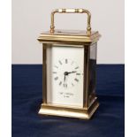 A POST WAR ENGLISH BRASS CASED CARRIAGE CLOCK, the white enamel dial inscribed Wm Widdop Est