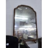 A WALNUT FRAMED SHAPED-TOP WALL MIRROR