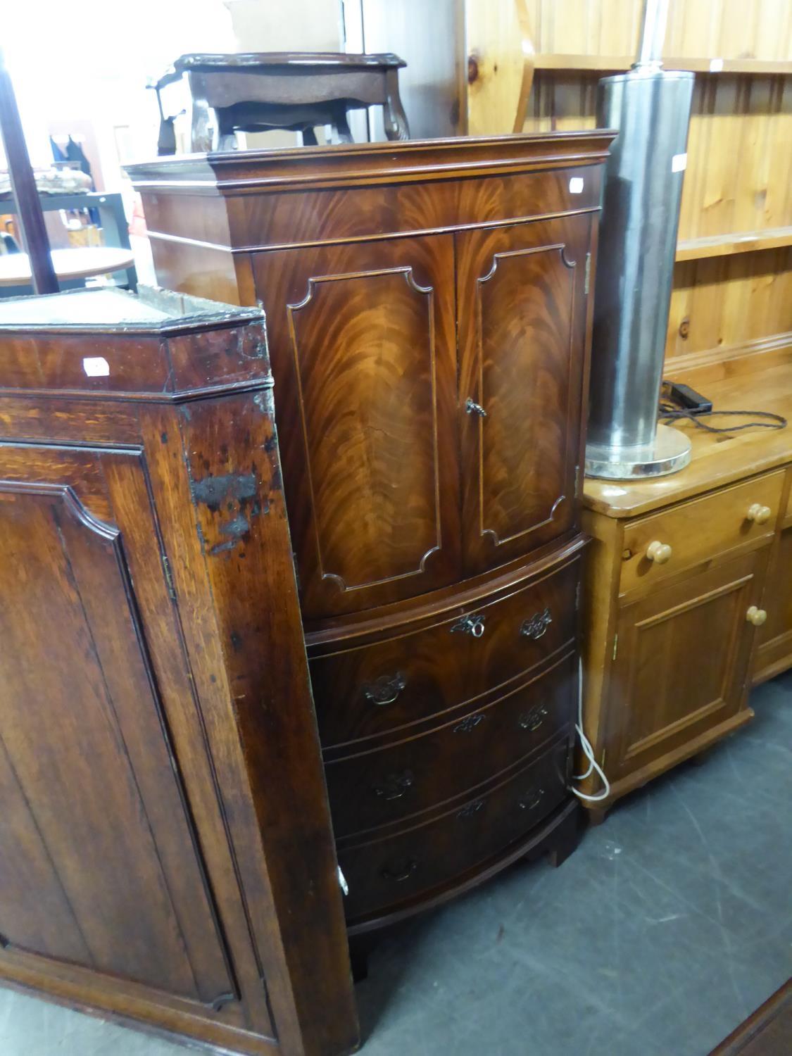 A REPRODUCTION MAHOGANY COCKTAIL CABINET, WITH INTERIOR LIGHTING TO THE CUPBOARD, OVER THREE DRAWERS