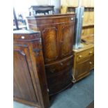 A REPRODUCTION MAHOGANY COCKTAIL CABINET, WITH INTERIOR LIGHTING TO THE CUPBOARD, OVER THREE DRAWERS