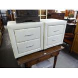 A PAIR OF BEDSIDE PEDESTALS OF TWO DRAWERS COVERED IN CREAM PADDED VINYL